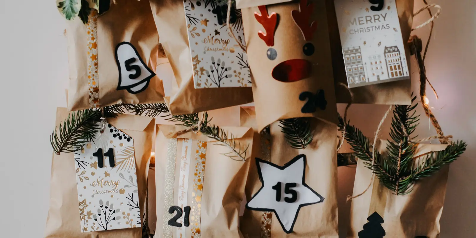 Handmade advent calendar of numbered kraft paper bags with greenery