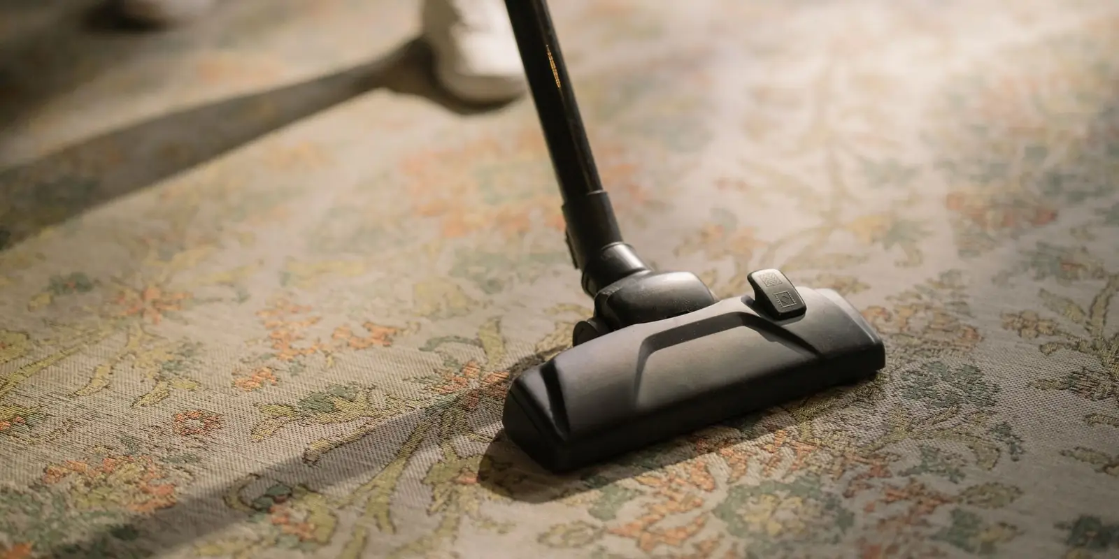 Vacuuming a patterned rug in a living room