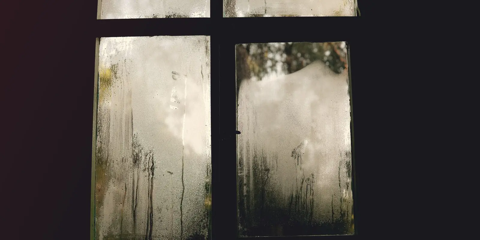 A misted-up window with condensation running down the glass