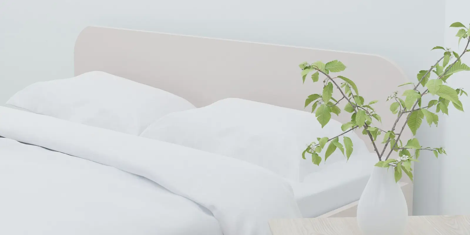 A neatly made bed with white linen and pillows beside a plant in a vase