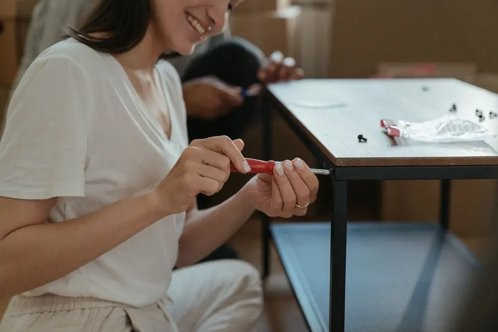 Woman assembling flat-pack furniture at a table