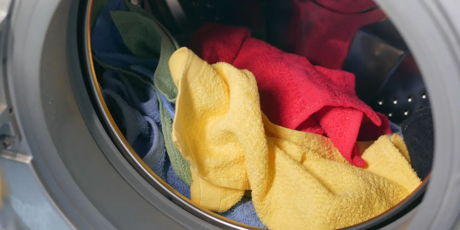 Colourful towels inside the drum of a front-loading washing machine